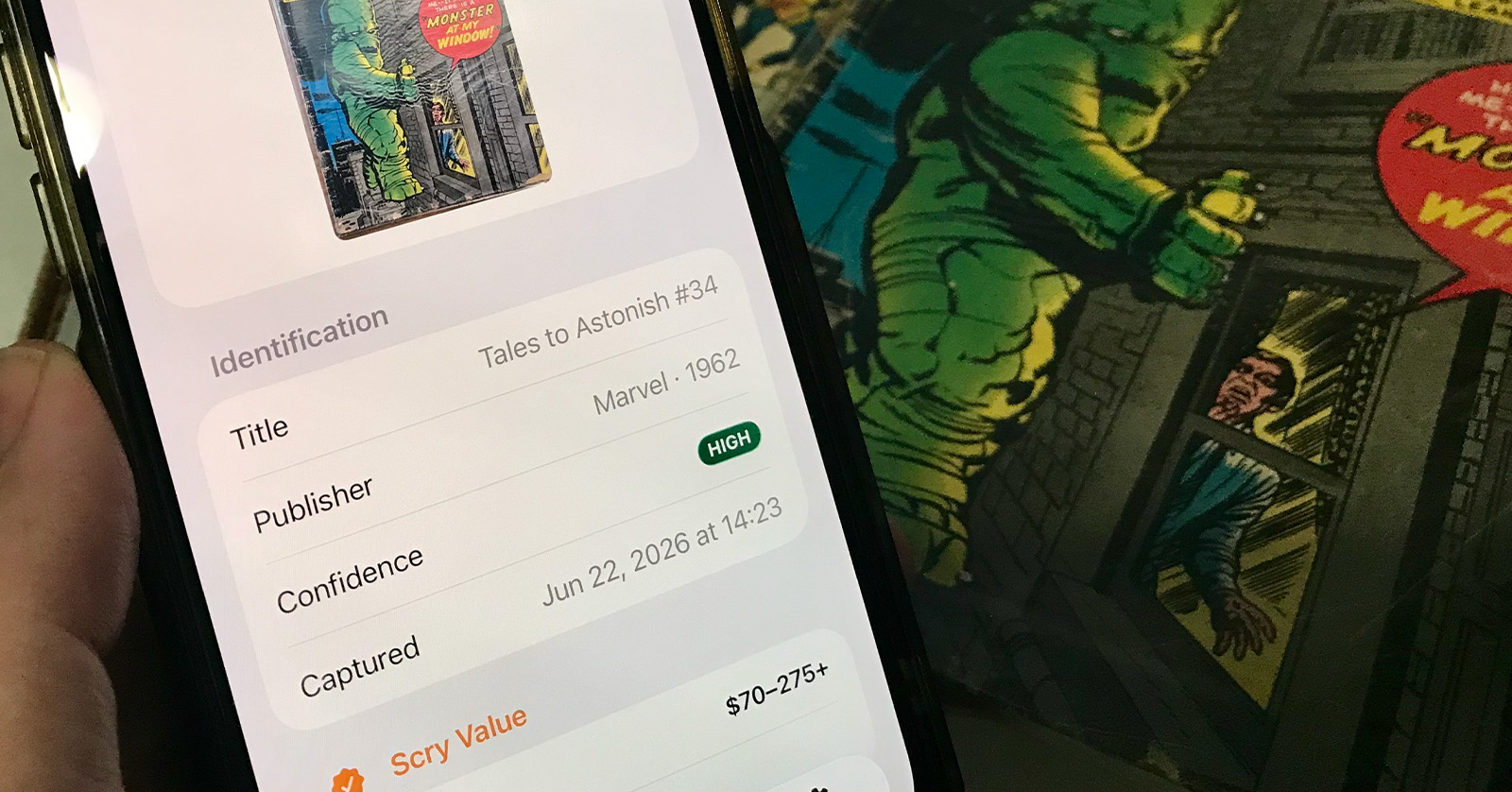 A hand holds a phone showing a Comic Scry scan result — a value tier and price range — beside the vintage Marvel comic it just identified.